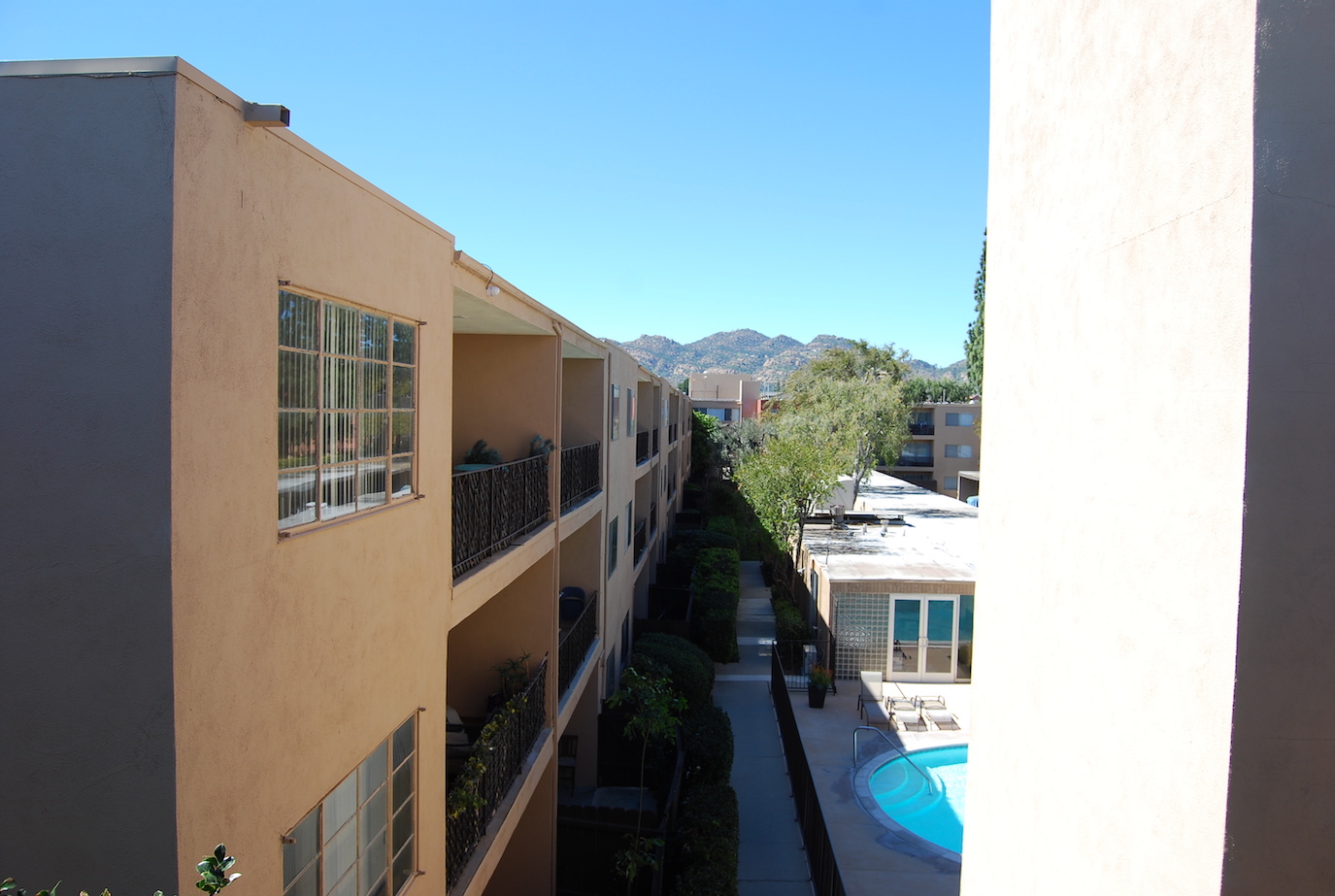 View of the complex from above, with beautiful landscaping. Mountains in the distance.